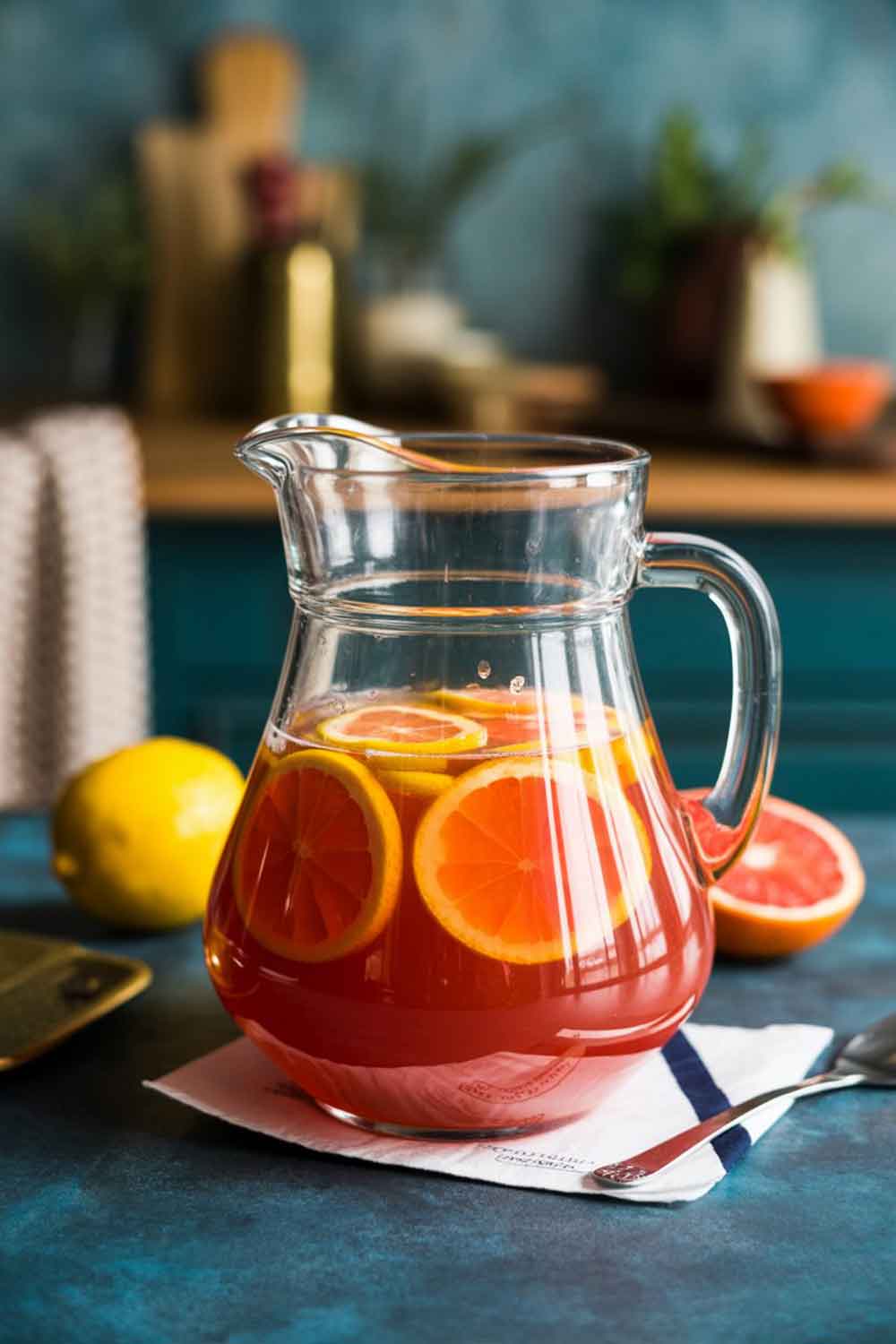 Classic Caribbean Rum Punch Glass pitcher filled with a vibrant citrus rum punch garnished with orange slices, perfect for parties — Easy Rum Punch Recipes For A Crowd.